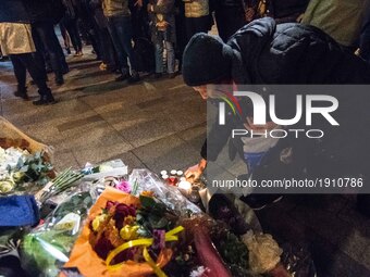 People bring flowers as they pay their respect at the site of a shooting on the Champs Elysees in Paris on April 21, 2017, a day after a gun...