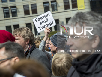 A man attending the 'March for Science' holds a banner reading 'facts are trump' in Berlin, Germany on April 22, 2017. Thousands of people r...