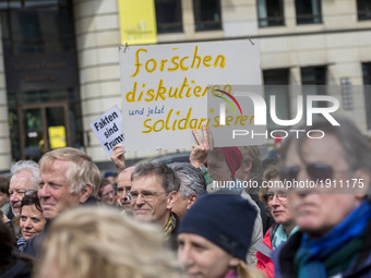 A man attending the 'March for Science' holds a banner reading 'research, discuss and now exoress solidarity' in Berlin, Germany on April 22...
