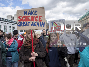 Two women attending the 'March for Science' hold banners reading 'make science great again' and 'I'm angry' in front of Brandenburg Gate in...