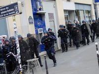 French anti-riot policemen stand guard the street during a demonstration for a 