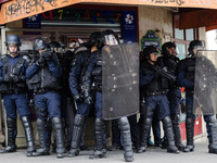 French anti-riot policemen stand guard the street during a demonstration for a 