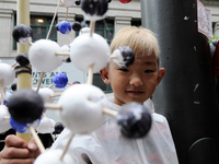 Pela Levin-Dorko, 8, of Philadelphia, shows a model of a Oxytocin molecule as he participates with his family in the National March for Scie...