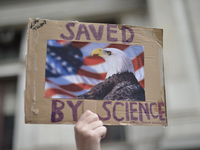 Protestor holds up a sign opposing conservative standpoints of the Trump-Administration regarding science and the environment. Thousands par...