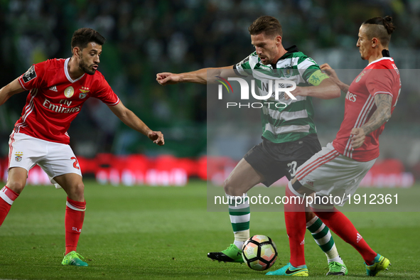 Sporting's Portuguese midfielder Adrien Silva (C ) vies with Benfica's Portuguese forward Pizzi (L) and Benfica's Serbian midfielder Ljubomi...