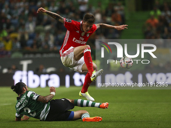 Benfica's Swedish defender Victor Lindelof (R) vies with Sporting's midfielder Ezequiel Schelotto during the Portuguese League  football mat...
