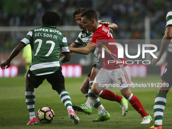 Benfica's Spanish defender Alex Grimaldo (R) vies with Sporting's forward Gelson Martins (L) and Sporting's midfielder Adrien Silva (2ndL) d...