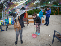 Young children are seen making giant bubbles from a soap solution in a kids park in Bydgoszcz, Poland on 22 April, 2017. (