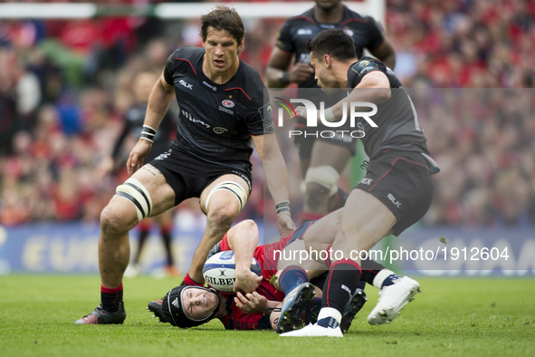 Tyler Bleyendaal of Munster tackled by Sean Maitland and Michael Rhodes of Saracens during the European Rugby Champions Cup Semi-Final match...