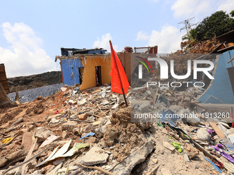 A Red flag that demarcate danger zones is seen among the debris of damaged houses  days after the collapse of a garbage mound in Meetotamull...