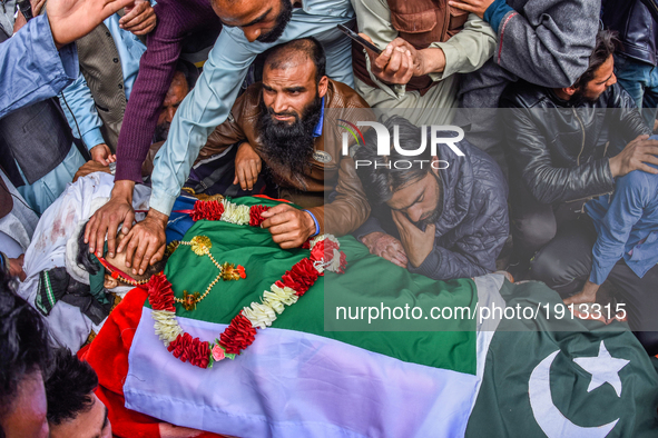Kashmiri Muslims touch the body of  Younis Maqbool Ganie, a pro Kashmir rebel killed in a gun battle with Indian government forces,  during...
