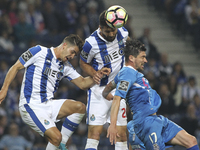 Porto's Brazilian defender Felipe (C) jumps with Porto's Portuguese forward Andre Silva (L) and Feirense player Cris (R) during the Premier...