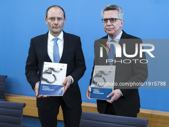 German Interior Minister Thomas de Maiziere (R) and Saxony's Interior Minister Markus Ulbig (L) hold a copy of the Police Criminal Statistic...