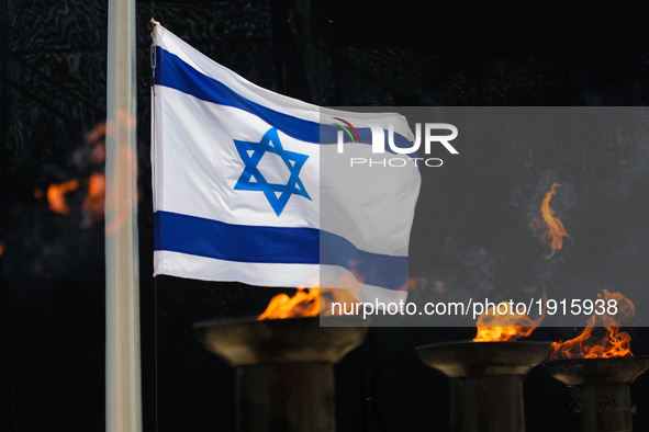 An Israeli flag behind torches is seen during the annual Holocaust Remembrance Day at the Yad Vashem Holocaust memorial in Jerusalem, Israel...