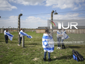 Girls taking photos by a barbed wire fence during the 'March of the Living' at the former Nazi-German Auschwitz Birkenau concentration and e...
