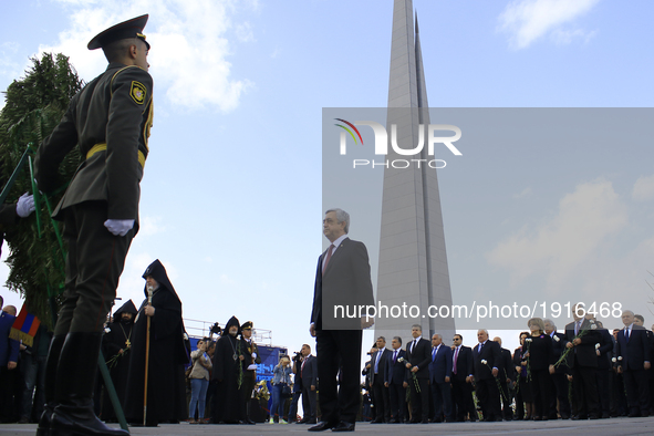 Armenian President Serzh Sargsyan (C) presents a wreath to the Genocide Memorial during a ceremony marking the 102nd anniversary of the Arme...