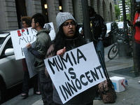 A demonstrator holds a sign declaring the innocence of Mumia Abu-Jamal outside of the Criminal Justice Center in Philadelphia, PA on April 2...