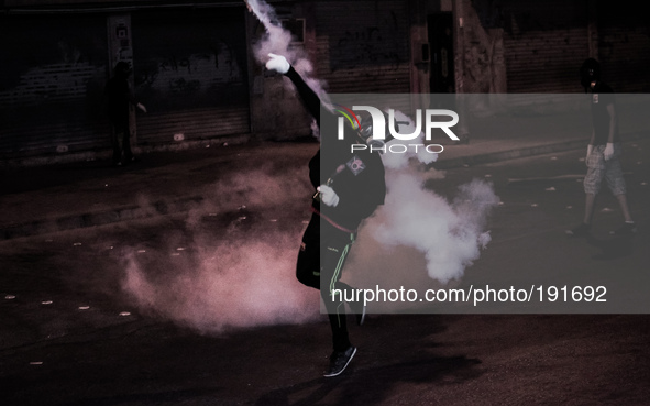 Bahrain , Sitra - protester returning tear gas canister to riot police , heavy clashes between protesters and riot police after suppressing...