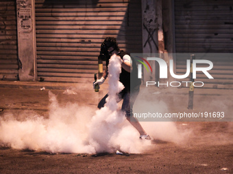 Bahrain , Sitra - protester ready to return tear gas canister , heavy clashes between protesters and riot police after suppressing a peacefu...