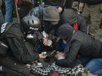 A young protester is quickly assisted by press members and other protesters after she fell and hurt herself during a panic moment where poli...