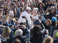 Pope Francis caresses a child during his weekly general audience in St. Peter's Square, Vatican City, 26 April 2017. (