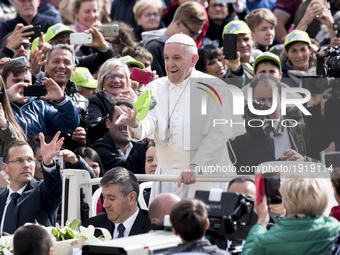 Pope Francis catches a hat tossed by a faithful during his weekly general audience in St. Peter square at the Vatican, Wednesday, April 26,...