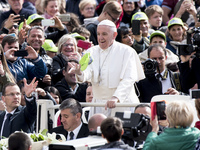 Pope Francis catches a hat tossed by a faithful during his weekly general audience in St. Peter square at the Vatican, Wednesday, April 26,...