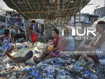 Maricel Dalotdot (C) passes the time with her children in their makeshift home on top of a garbage dumpsite in Manila, Philippines, April 26...