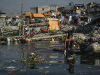 A resident (R) paddles his makeshift boat to collect recyclables along a polluted river in Manila, Philippines, April 26, 2017.

(