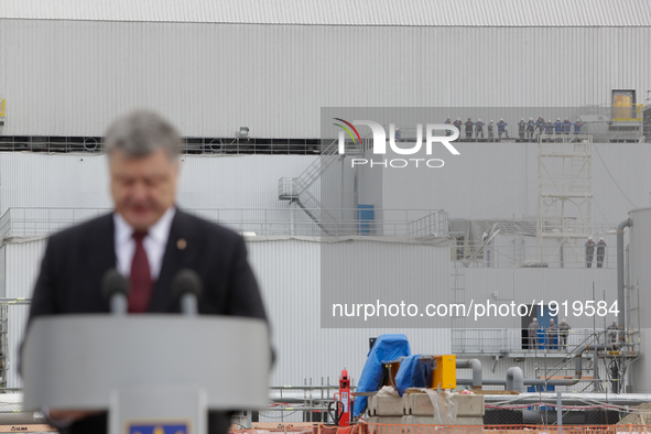 Employees of Chornobyl NPP safe confinement is seen listening President Poroshenko's speech near the confinement during the meeting of Petro...