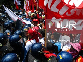 Workers and protesters scuffle with policemen as they attempt to reach the vicinity of the US Embassy during a rally in Manila, Philippines...