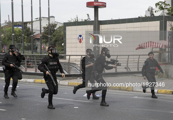 Police are seen running past makeshift barricades as they chase protesters through the streets during a May Day demonstration on May 1, 2017...