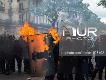 French CRS anti-riot police officers are engulfed in flames as they face protesters during a march for the annual May Day workers' rally in...