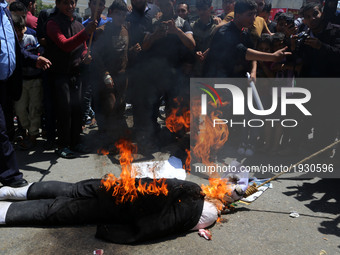 Demonstrators in Gaza against President Mahmoud Abbas burn a picture during mass demonstrations in the Gaza Strip on 2 May 2017 (