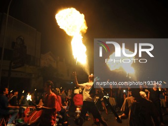 SURAKARTA, CENTRAL JAVA, INDONESIA - July 27: Indonesian muslims spitting fire using kerosene during take part a javanese ritual called 