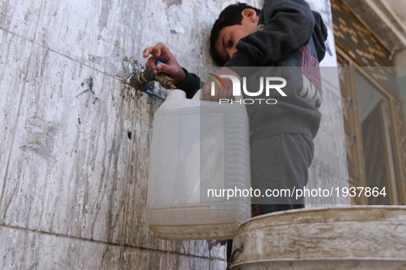 A Syrian boy carrying water in the rebel-held town of Douma, on the eastern outskirts of the Syrian capital Damascus, on 6 May 2017 after th...