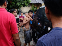 Police escort an inmate back to jail in Pekanbaru in Riau province on May 6, 2017, a day after more than 200 inmates broke out of the city's...