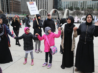 Muslim women and children form a 'circle of peace' during a rally against Islamophobia, White Supremacy & Fascism in downtown Toronto, Ontar...