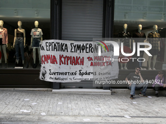 Entrance of an H&M store with banner against work on Sundays, in central Athens, Greece on Sunday May 7, 2017. In the new agreement between...