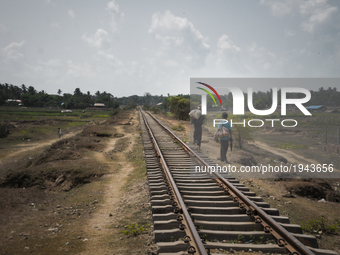 Two men walk along the desecrated train tracks that once connected the villages of Kone Doke Khar. Since the violence of 2012, they are no l...