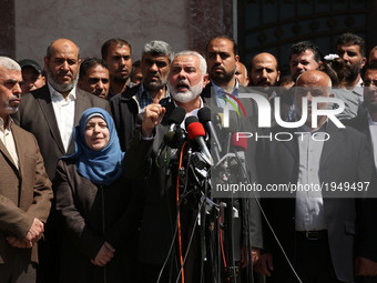 Supporters chant Islamic slogans as Hamas Supreme Leader Ismail Haniyeh, center, announces the arrest of a suspect in the March shooting dea...
