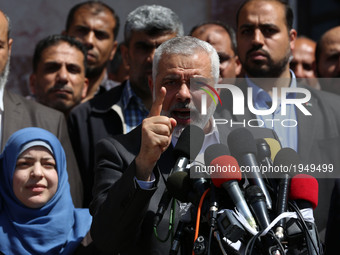 Supporters chant Islamic slogans as Hamas Supreme Leader Ismail Haniyeh, center, announces the arrest of a suspect in the March shooting dea...