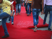 Palestinians walk on a red carpet during the Red Carpet Festival of Human Rights Films in the Gaza Port in Gaza City on May 12, 2017.
 (