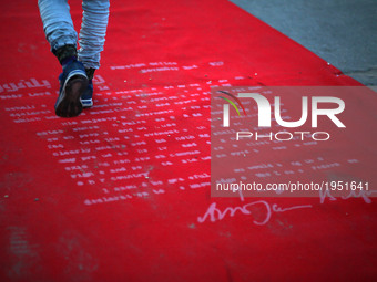 Palestinians walk on a red carpet during the Red Carpet Festival of Human Rights Films in the Gaza Port in Gaza City on May 12, 2017.
 (