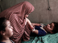 A Palestinian woman along with her wounded daughter who was injured in an air israeli strike, on July 28, 2014, in Gaza. A strike in a publi...