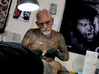 An artist works on a man during Athens's International Tatoo Convention, at the Olympic Tae Kwon Do Centre, on Saturday May 13, 2017. The vi...
