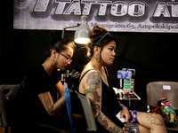 An artist works on a young woman during Athens's International Tatoo Convention, at the Olympic Tae Kwon Do Centre, on Saturday May 13, 2017...