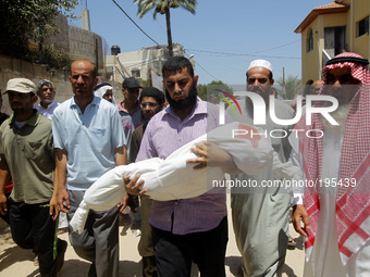 A Palestinian relatives carry the body of five year old, Rana Duheir, a Palestinian girl killed in an Israeli air strike, during her funeral...