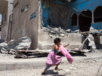 A Palestinian girl runs away in the heavy bombarded area of Shati district, Gaza, after hearing an Israeli drone flying low. Most of the Pal...