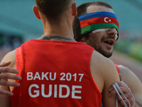 Nurlan Ibrahimov of Azerbaijan celebrates with his guide Vadim Ryabichin the win in Men's 100m T11 final, during an athletic event at Baku 2...
